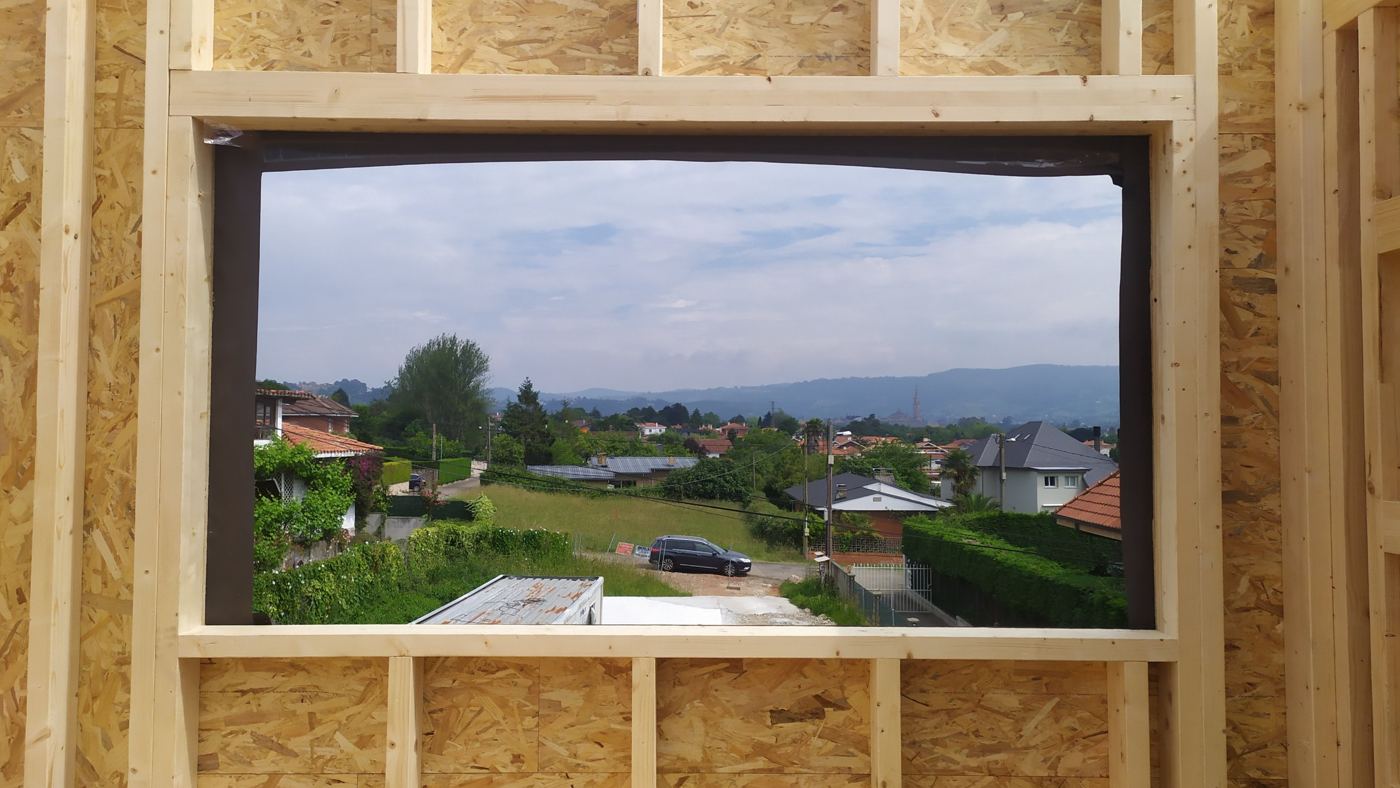 A window in the timber frame frames the landscape during construction of Casa Albion